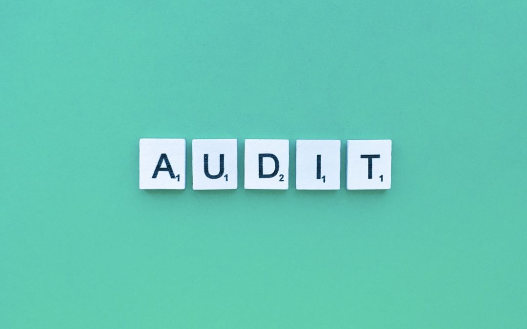 the word audit spelled in scrabble tiles