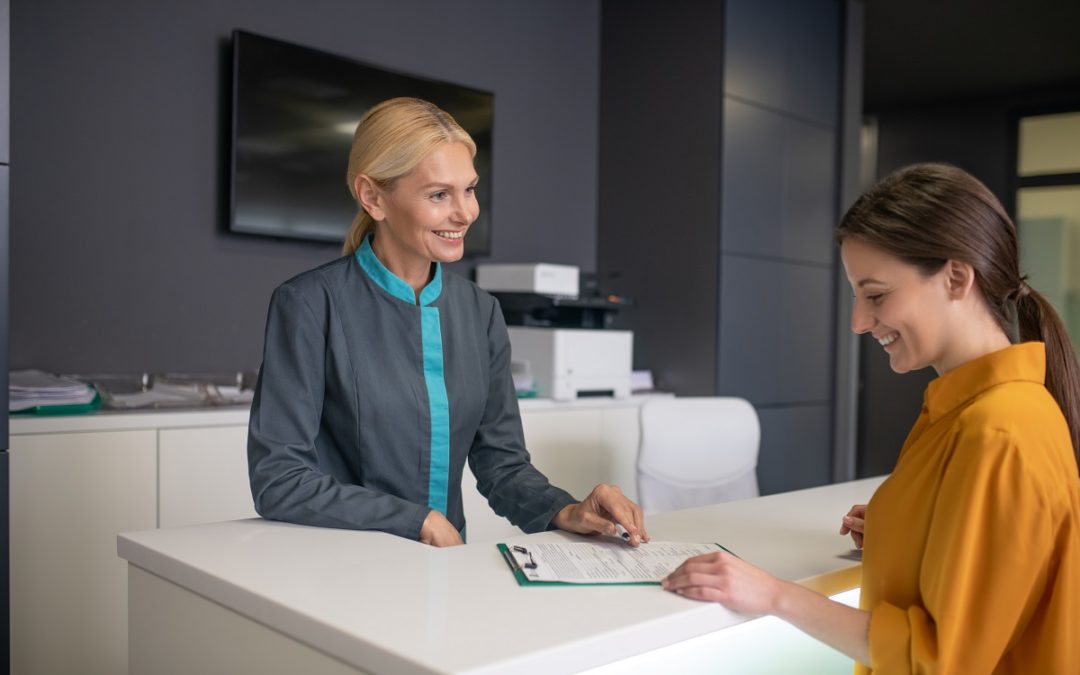 a receptionist checking in a visitor